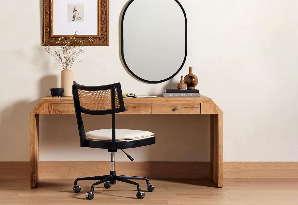 Home office desk and rolling chair, with mirror and wall art