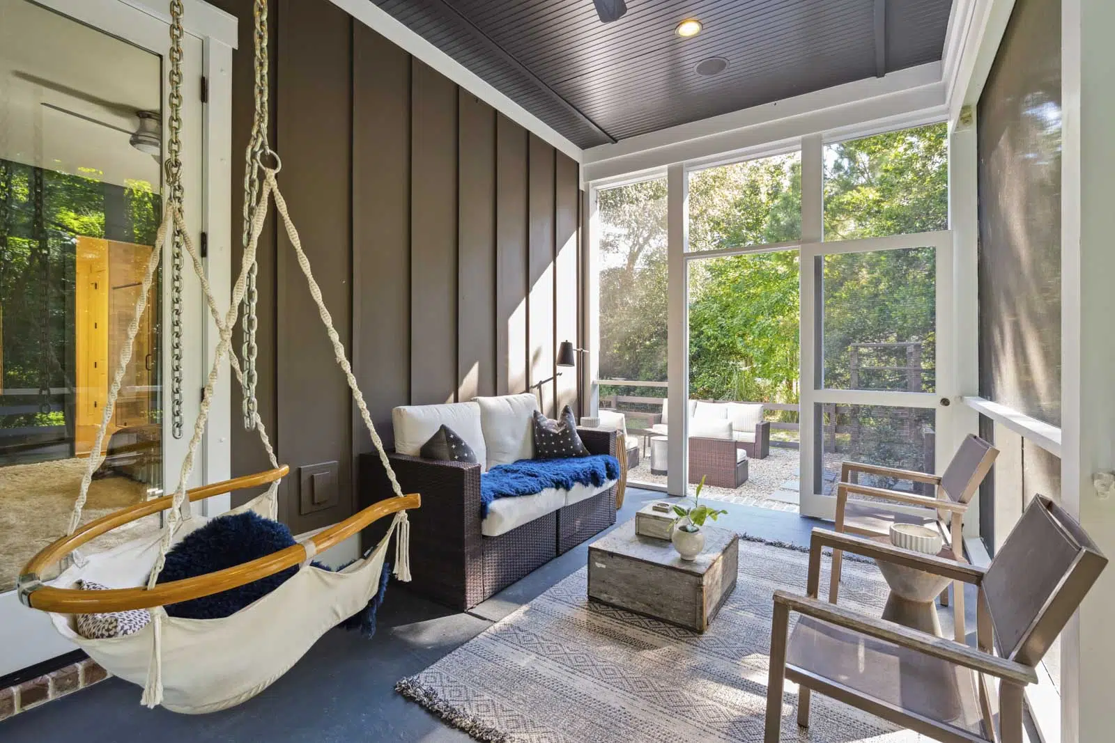 Hanging swing chair and patio furniture in screened porch